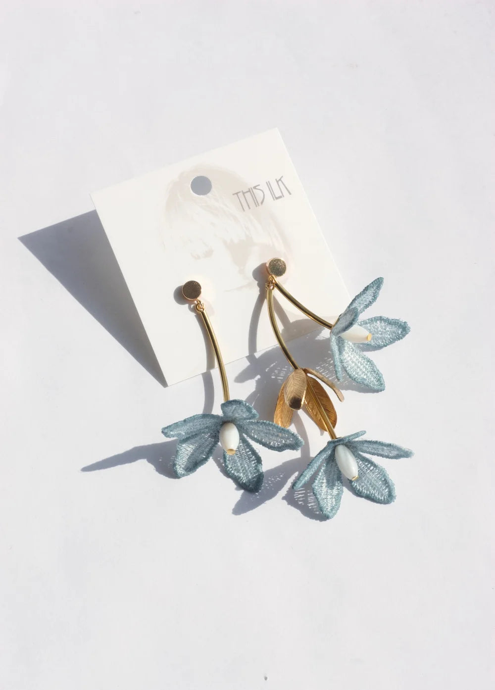Tahitian gardenia flower earring by Ilk Jewelry featuring a delicate floral design in vintage lace  and gold-tone setting.