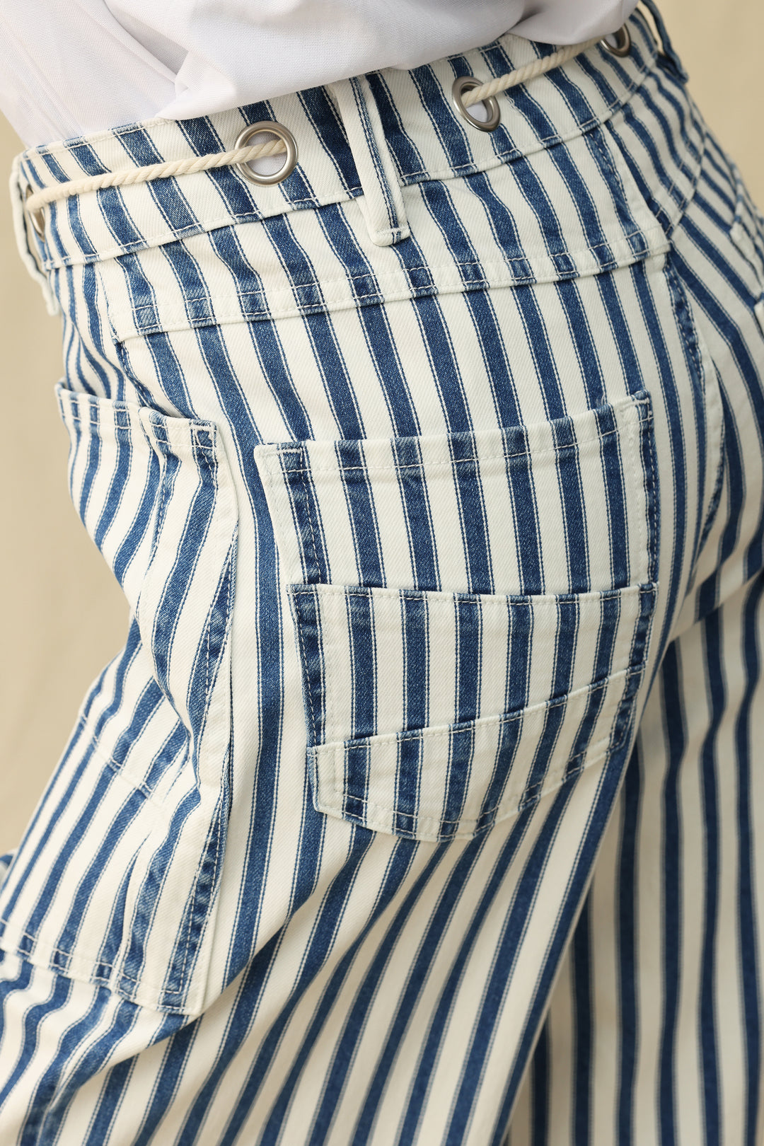 Close-up of blue and white striped pants with a beige background