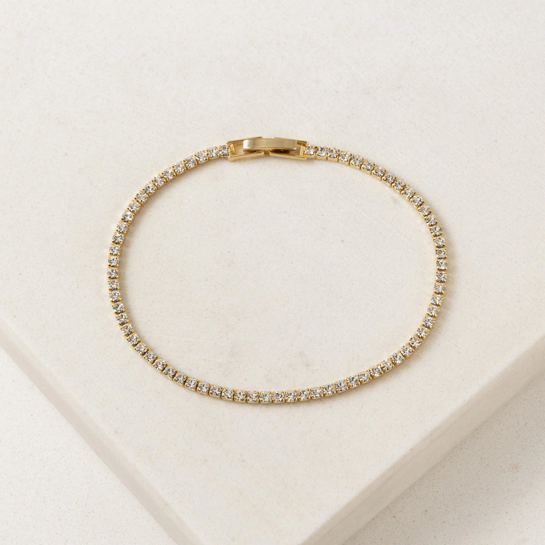 Gold bracelet with diamonds on a beige background
