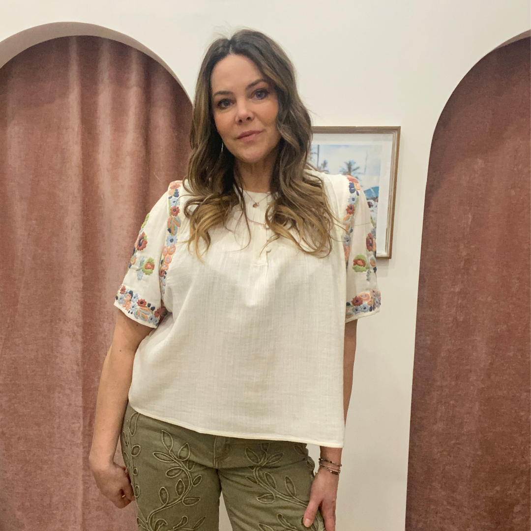 Louizon embroidered badge blouse, a stylish women's top with detailed floral embroidery and classic neckline.