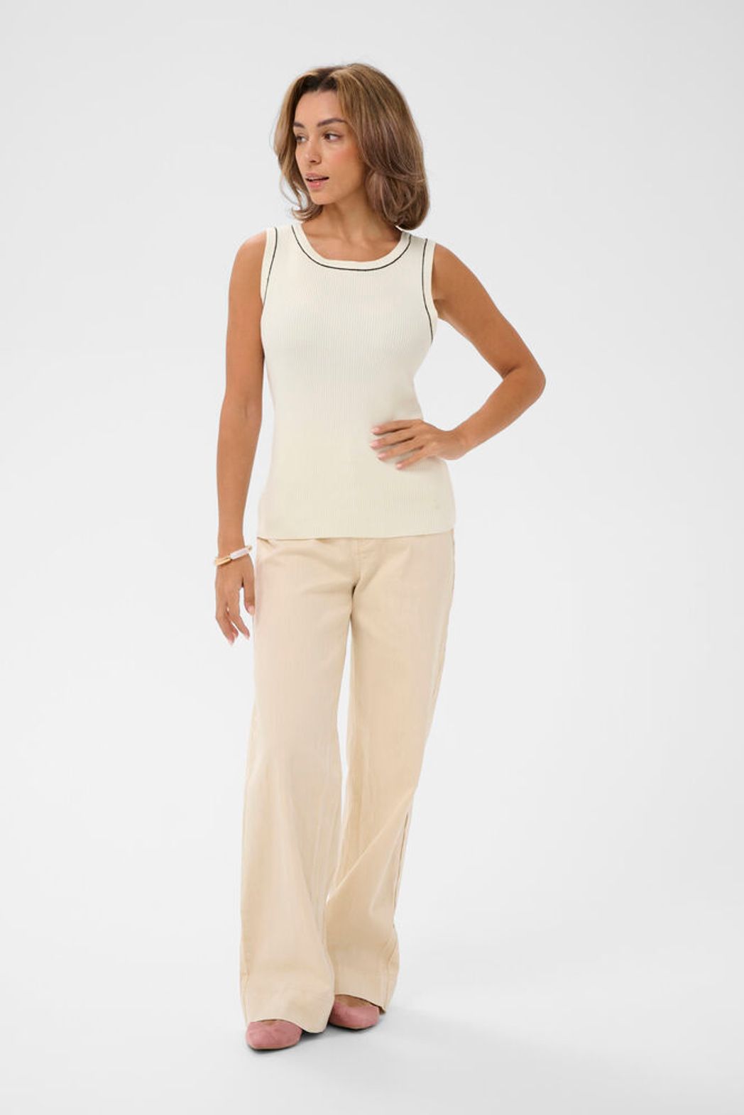 Cream Vilea ribbed knit tank top shown on a hanger, featuring a fitted sleeveless design with a high neckline and textured ribbed fabric.