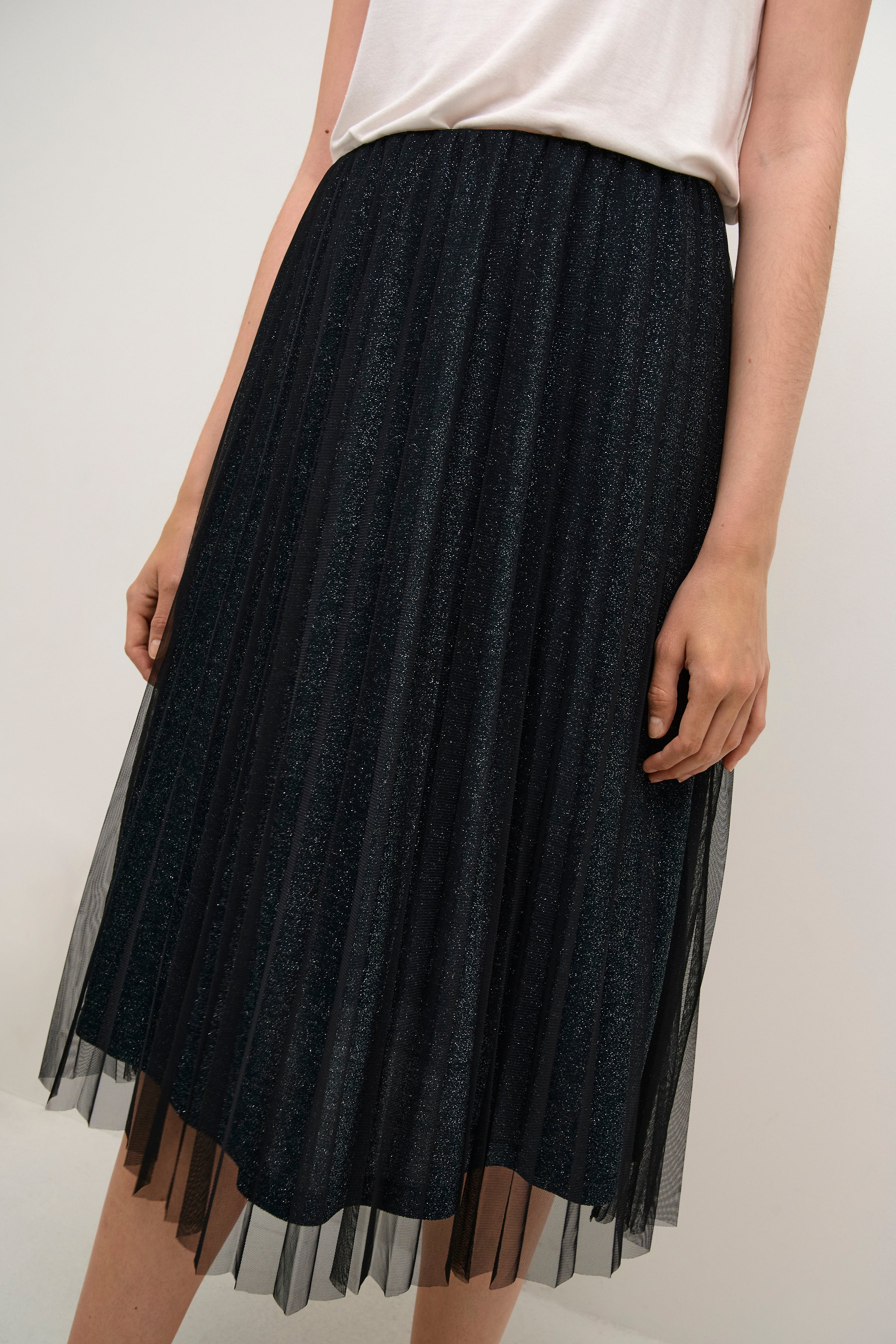 Black tulle skirt worn by a person on a white background