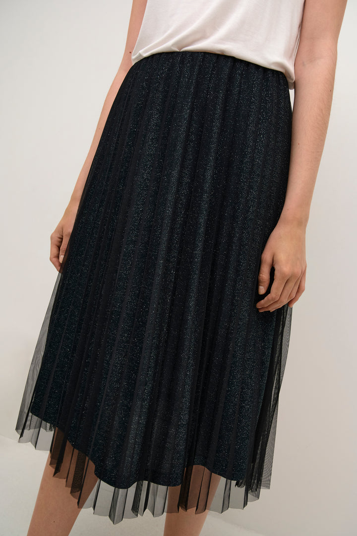 Black tulle skirt worn by a person on a white background