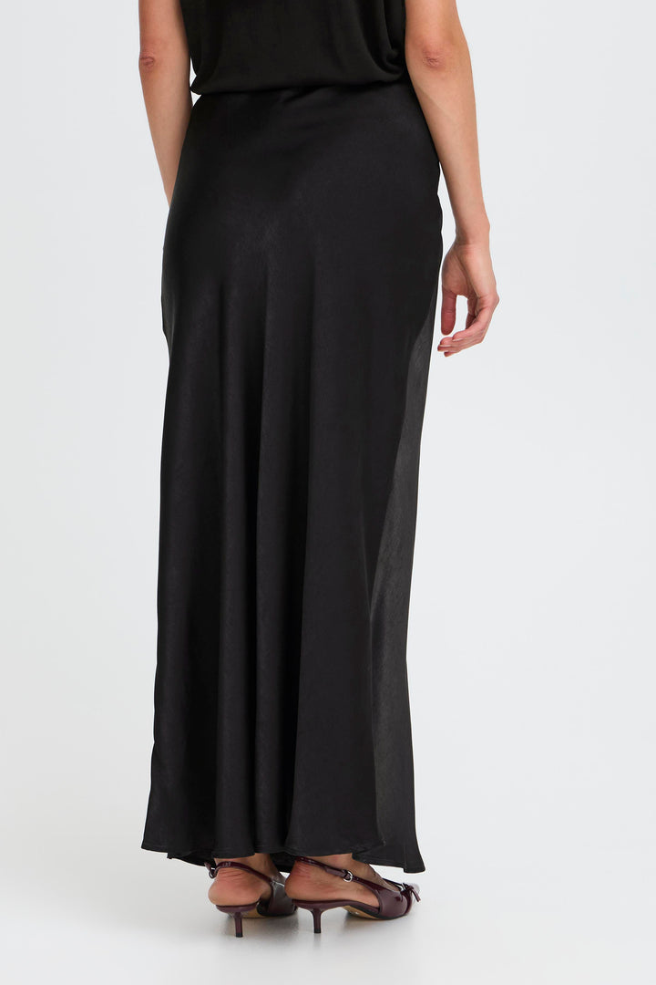 Black skirt worn by a person on a white background