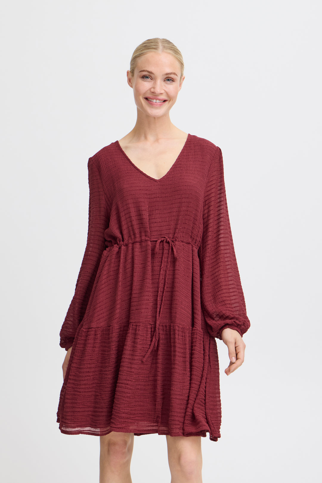 Woman wearing a burgundy dress on a white background