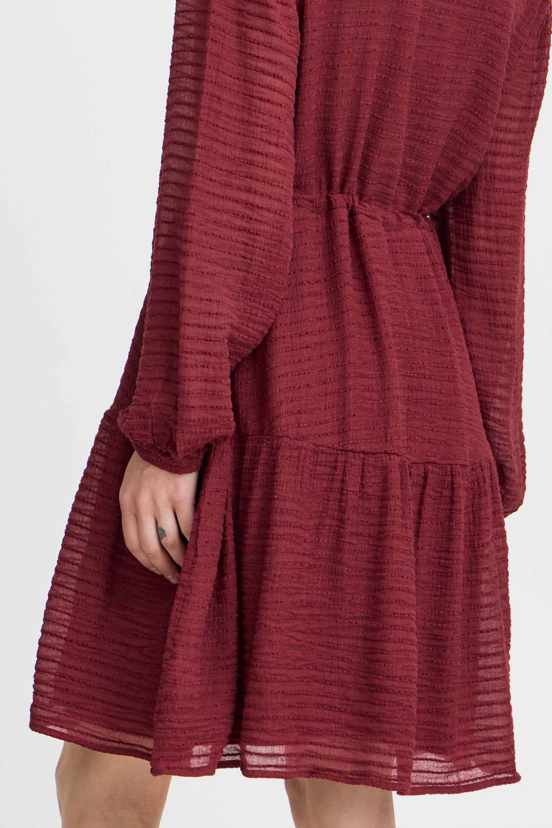 Maroon textured dress on a white background