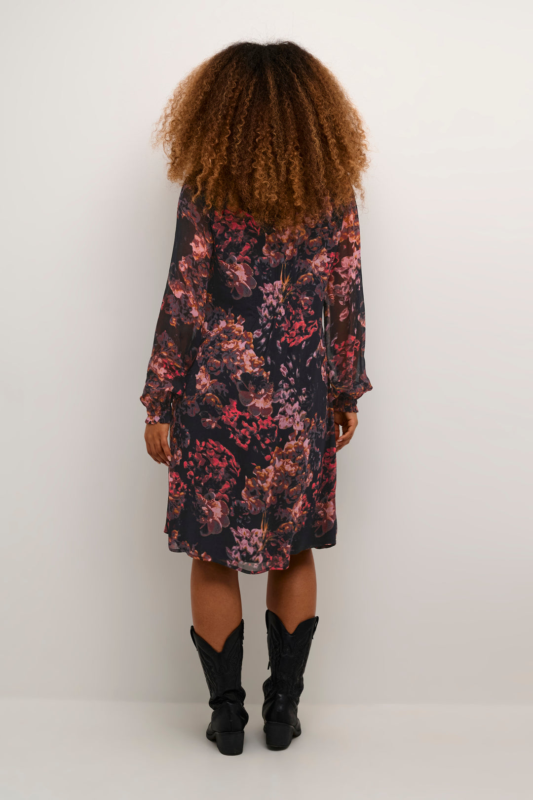 Person wearing a floral dress with a white background