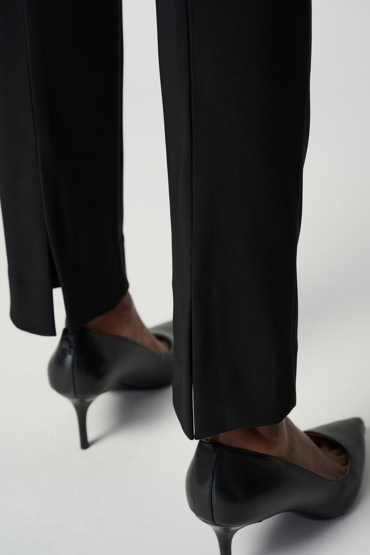 Black high-heeled shoes and pants on a white background