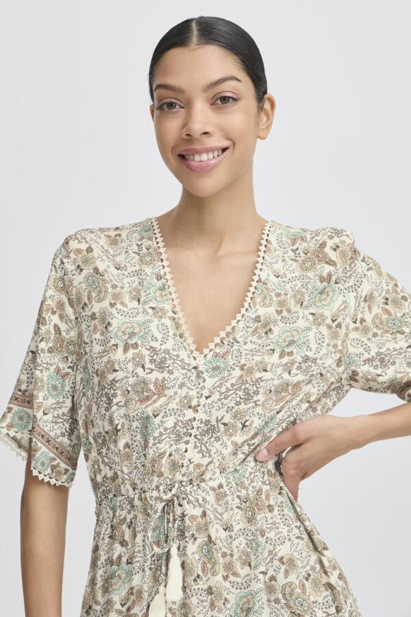 light green, beige and cream boho floral  maxi dress with tassel tie at waist and embroidered trim at v neckline. 