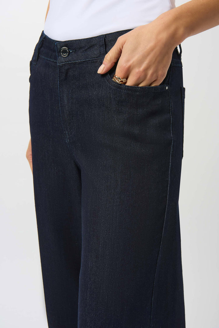Person wearing dark blue pants with a white background
