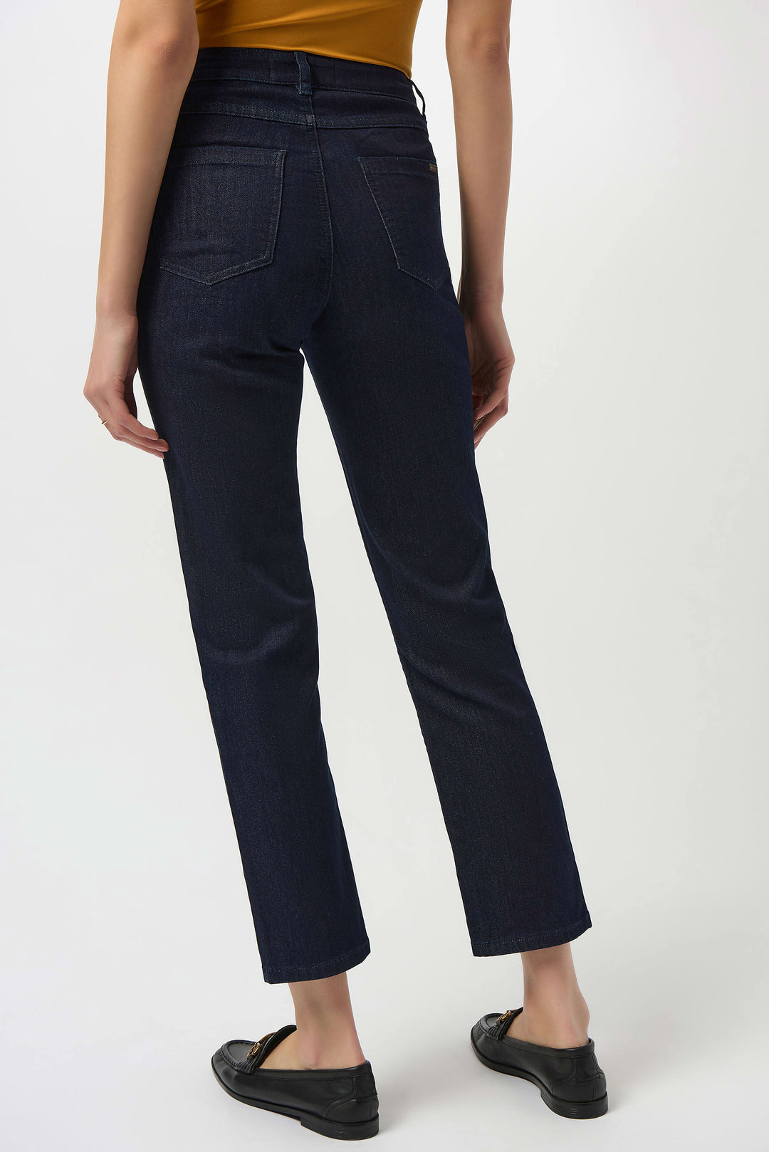 Person wearing dark blue jeans on a white background