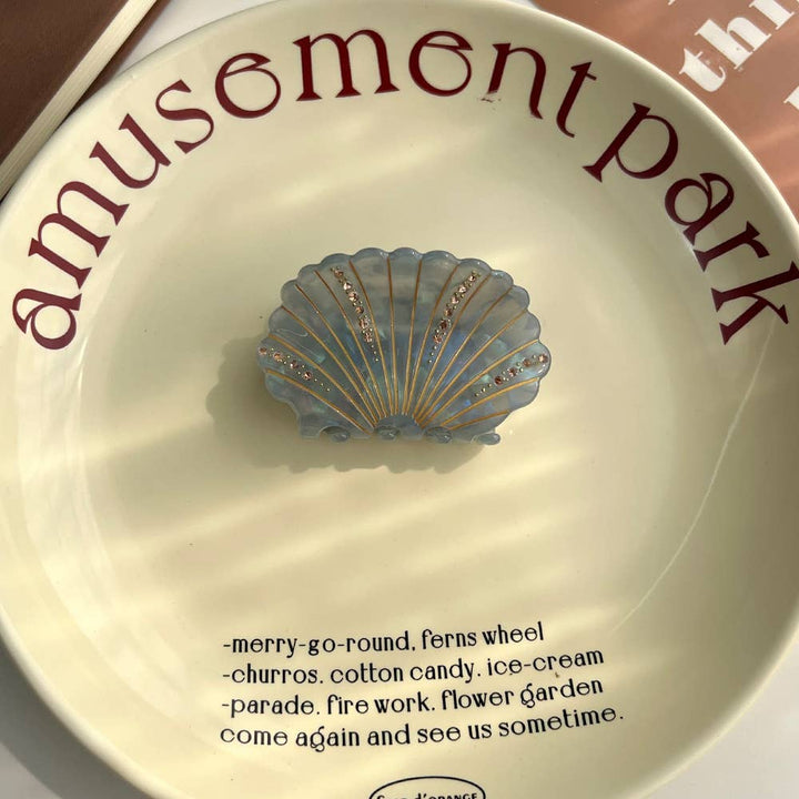 LadyJuneAccessories sea shell claw clip holding hair, featuring a detailed shell design for a stylish hair accessory.