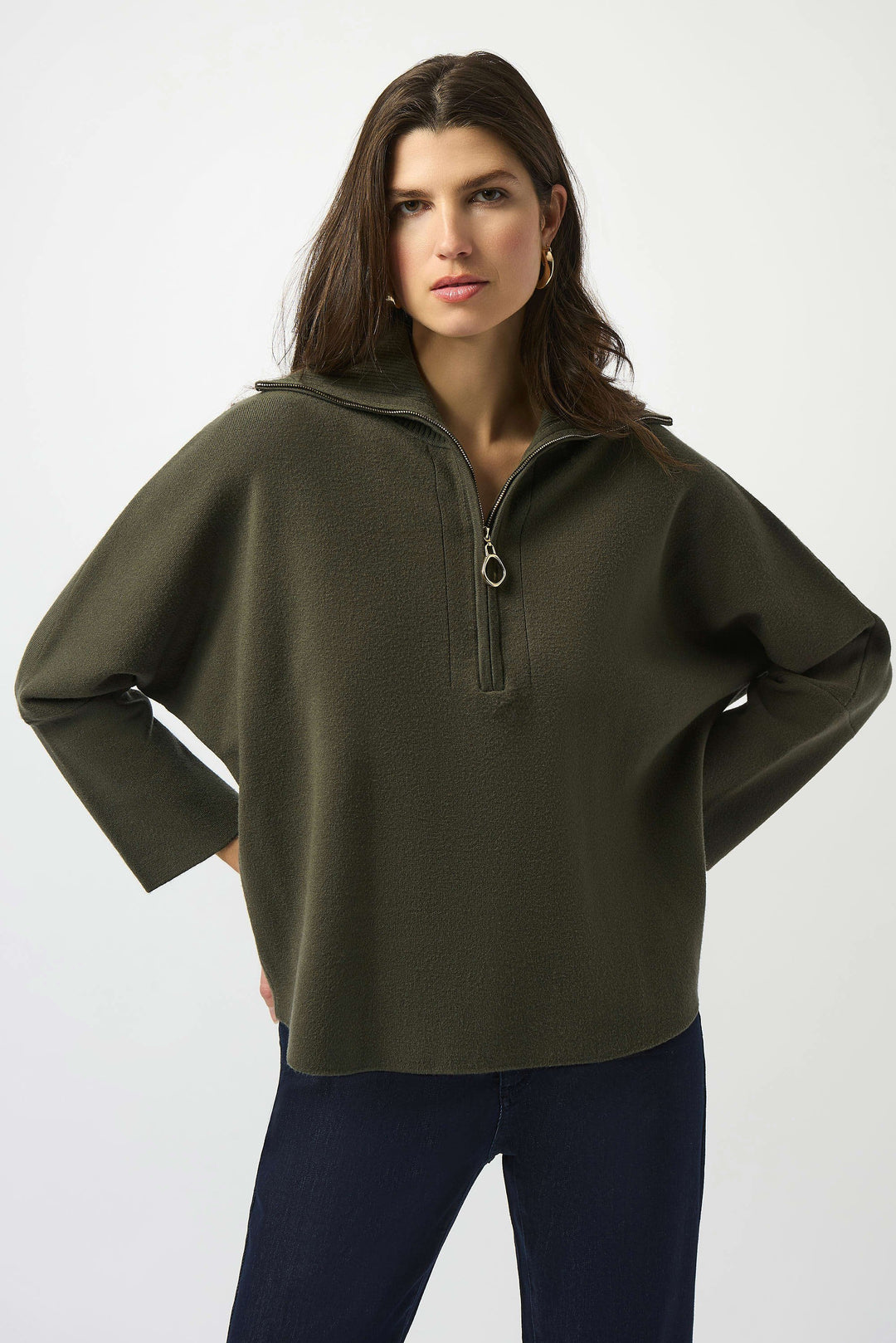Woman wearing an olive green pullover with a zipper on a white background