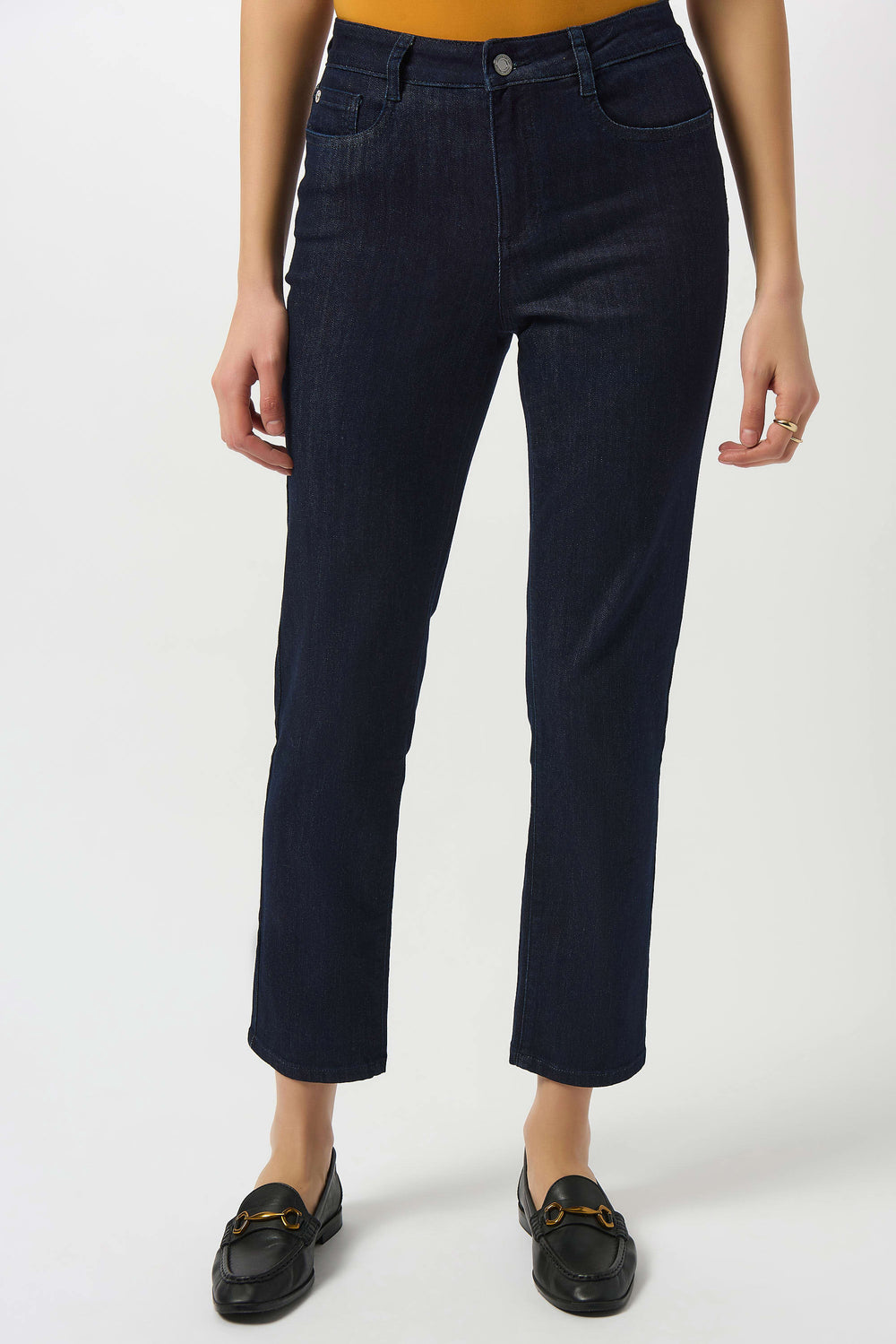Person wearing dark blue jeans on a white background