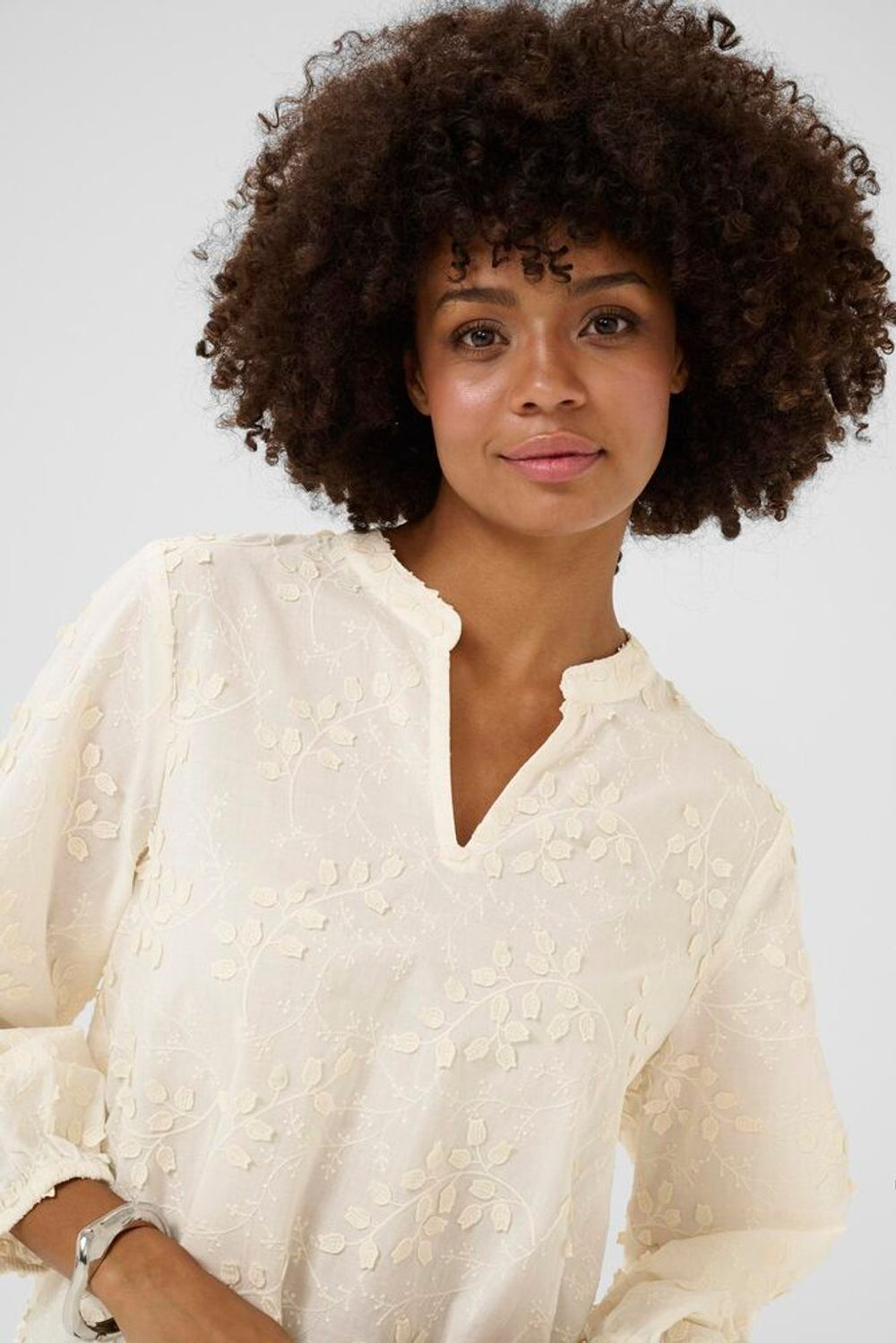 Woman wearing a white blouse with a plain background