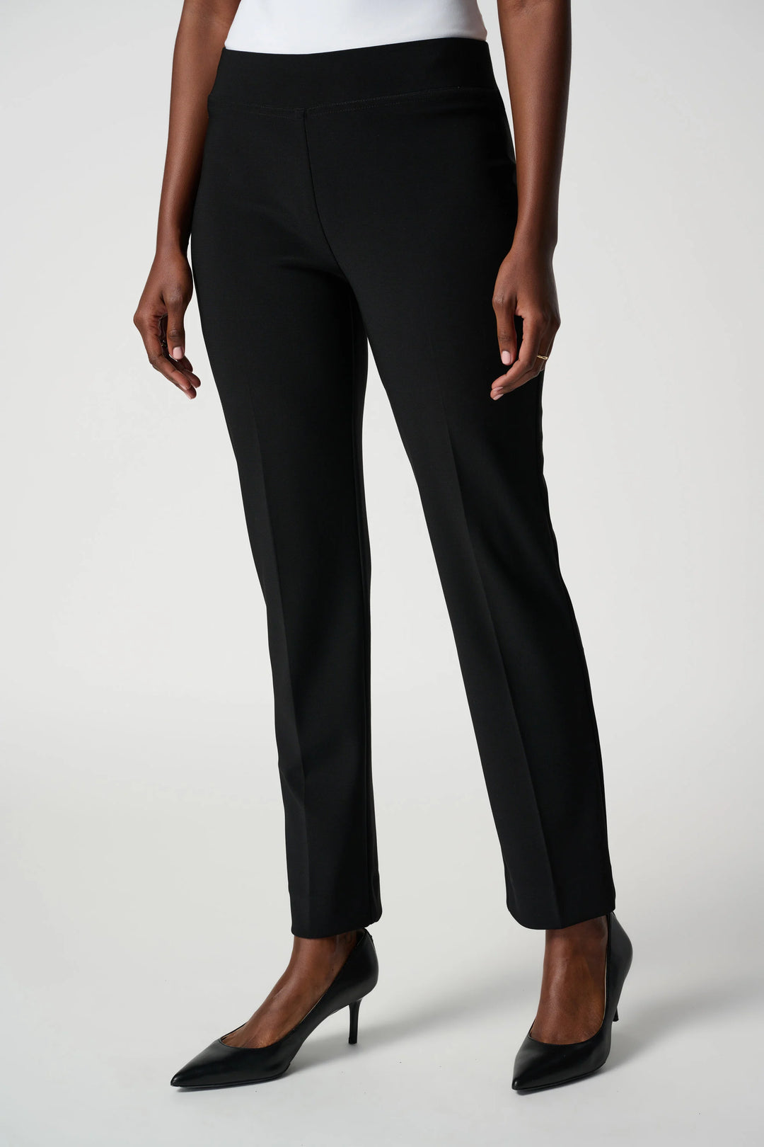 Black pants worn by a person on a white background